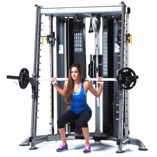 Fit woman doing squats with a barbell in Smith machine